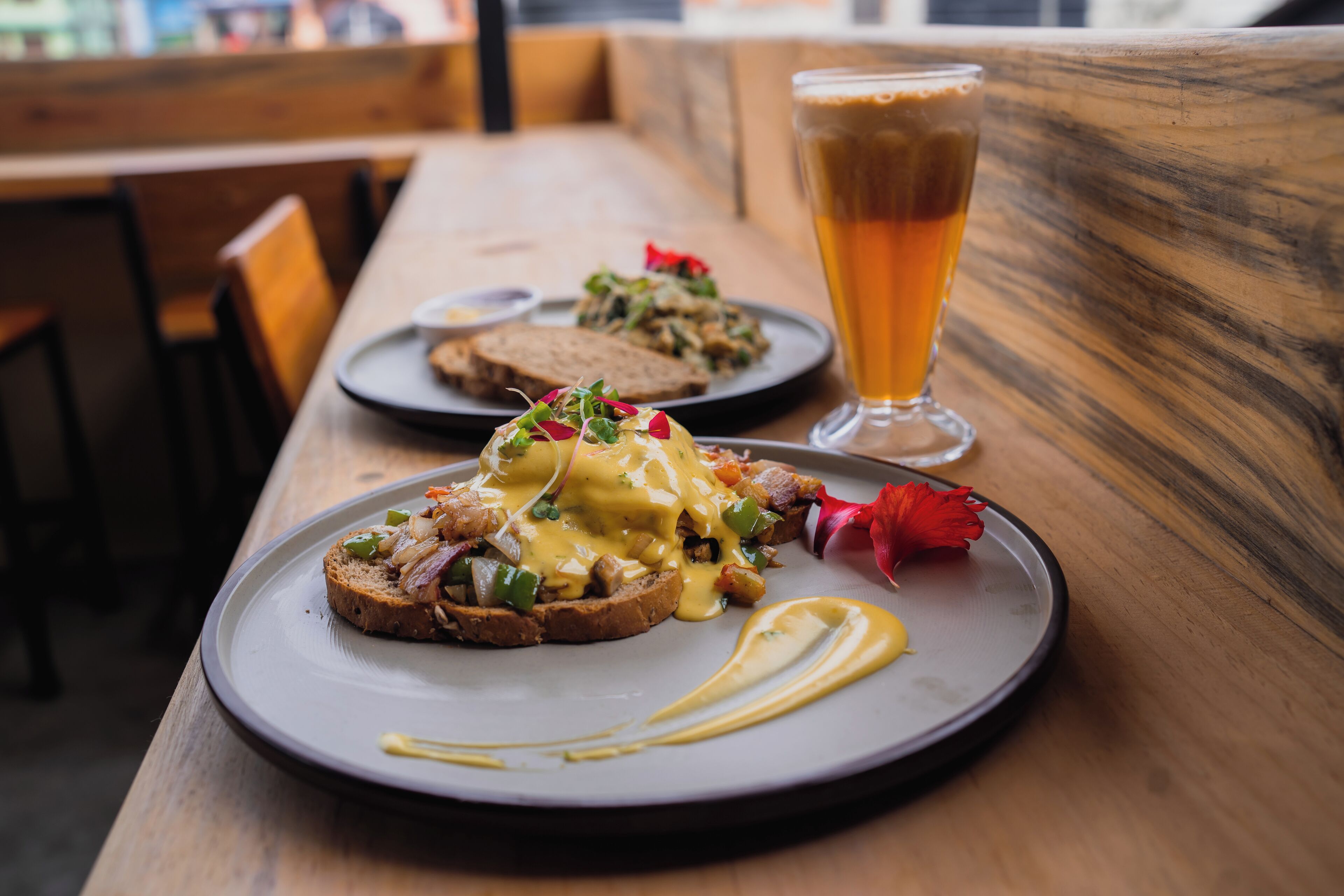 A dining table with a plate of food and a glass of beer.