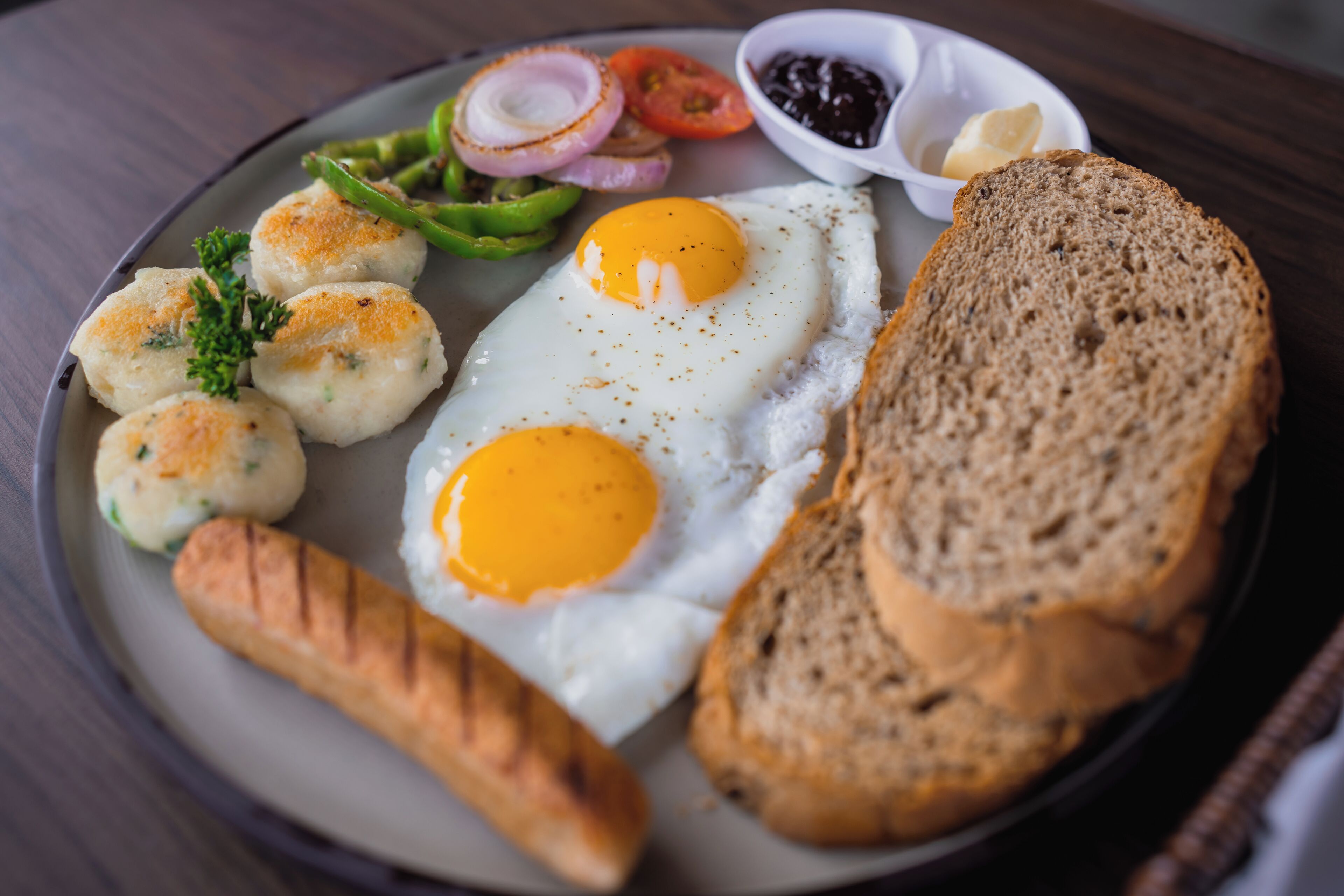 A plate with eggs, bread, and vegetables.