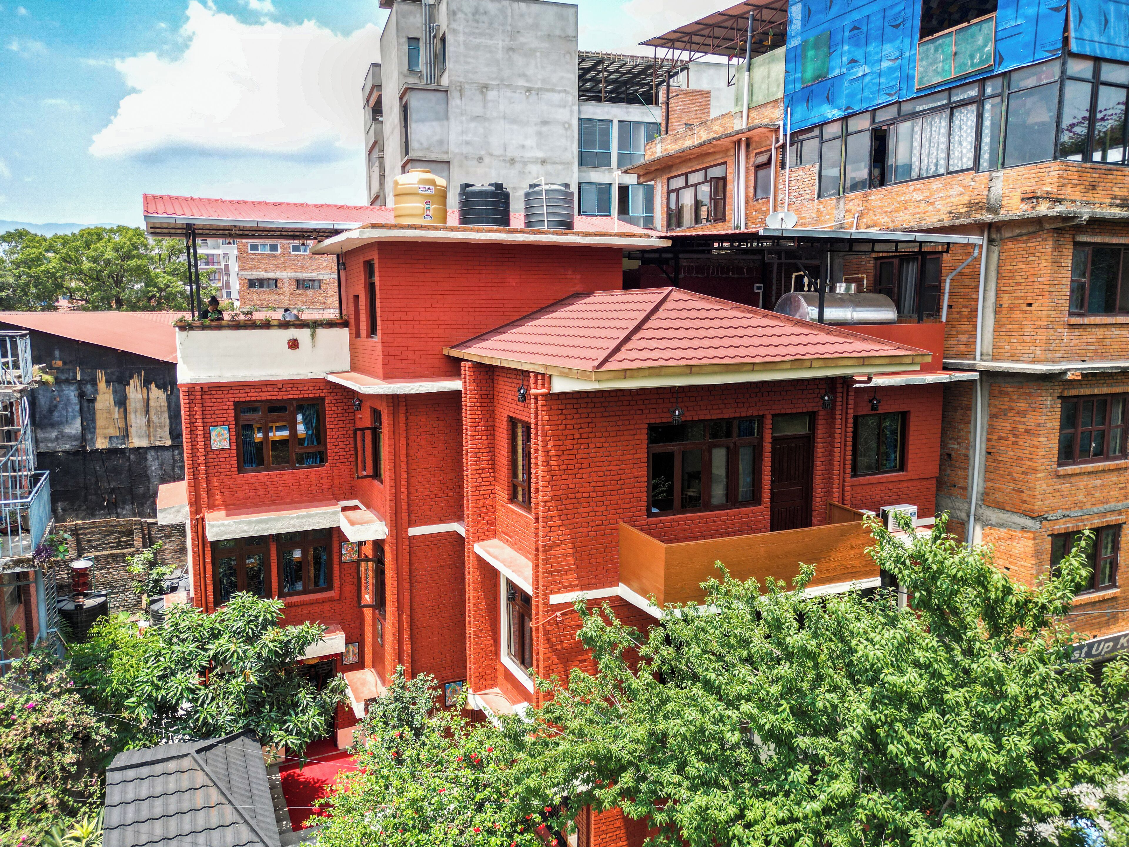 A multi-story building with red brick walls and a flat roof.