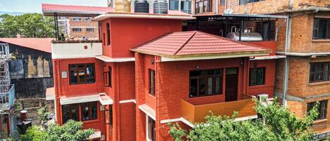 A multi-story building with red brick walls and a flat roof.