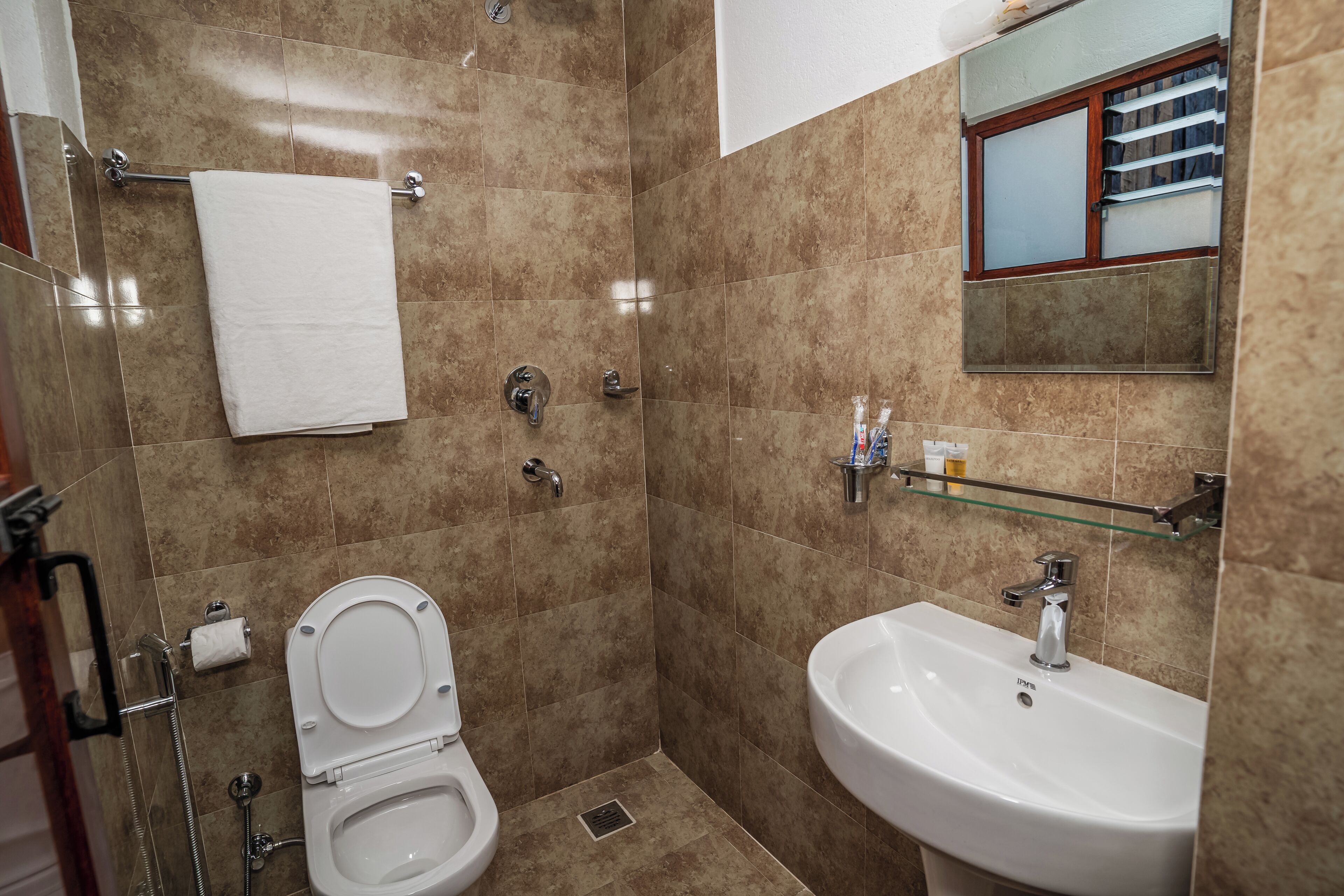 A bathroom with a toilet, sink, and shower.