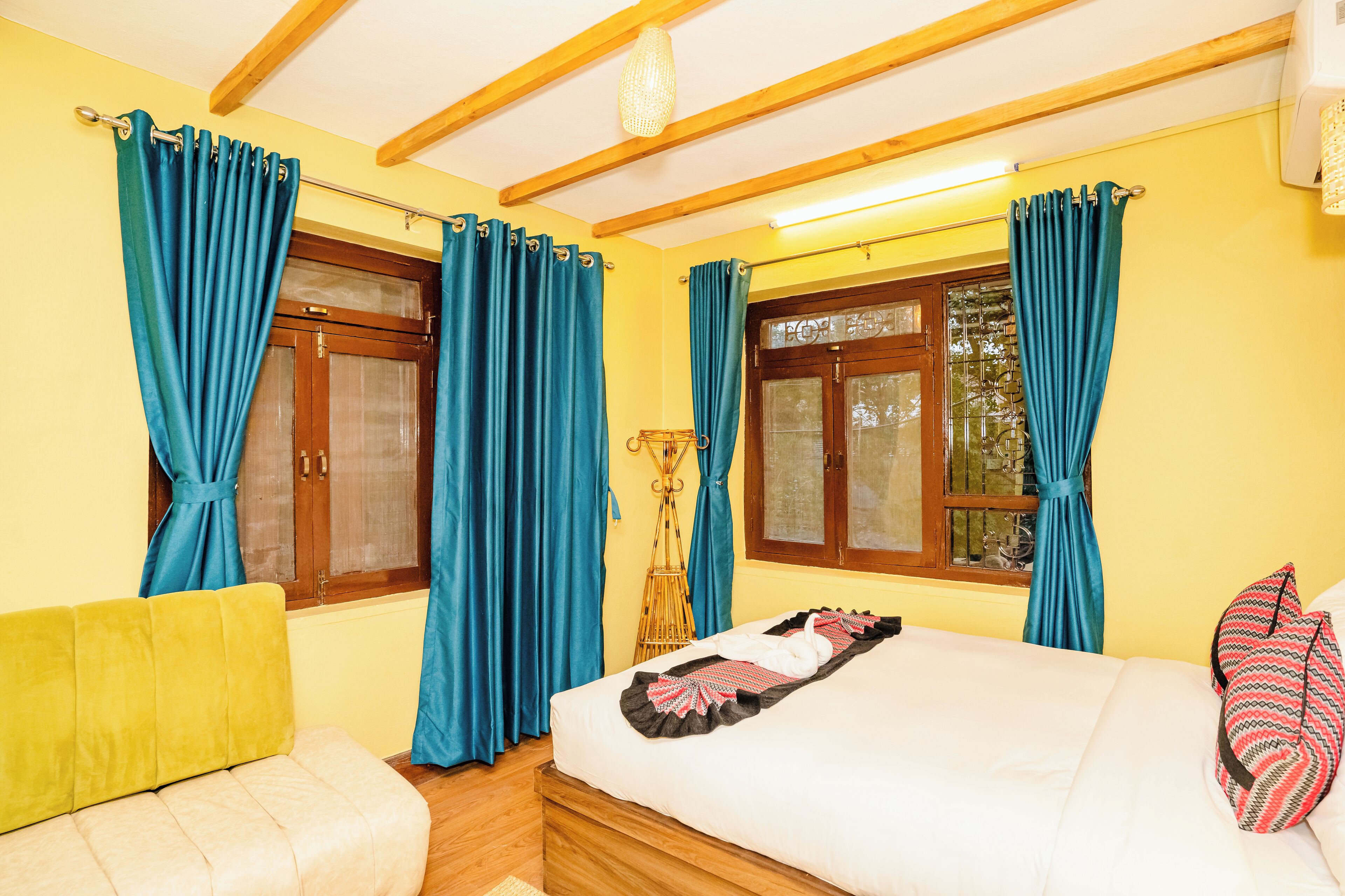 A room with a bed, a sofa, and curtains.