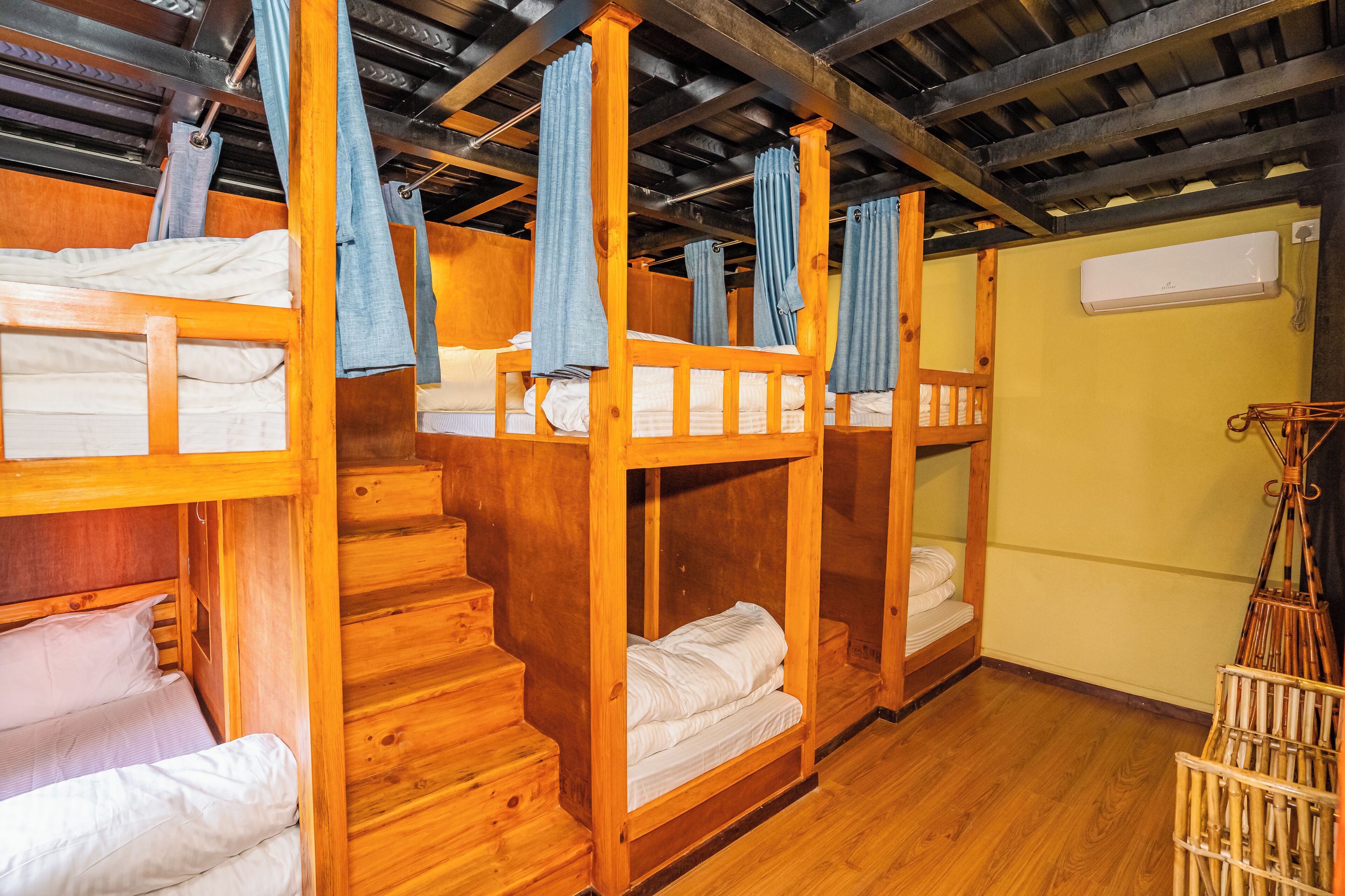 A cabin with bunk beds, wooden walls, and a staircase.