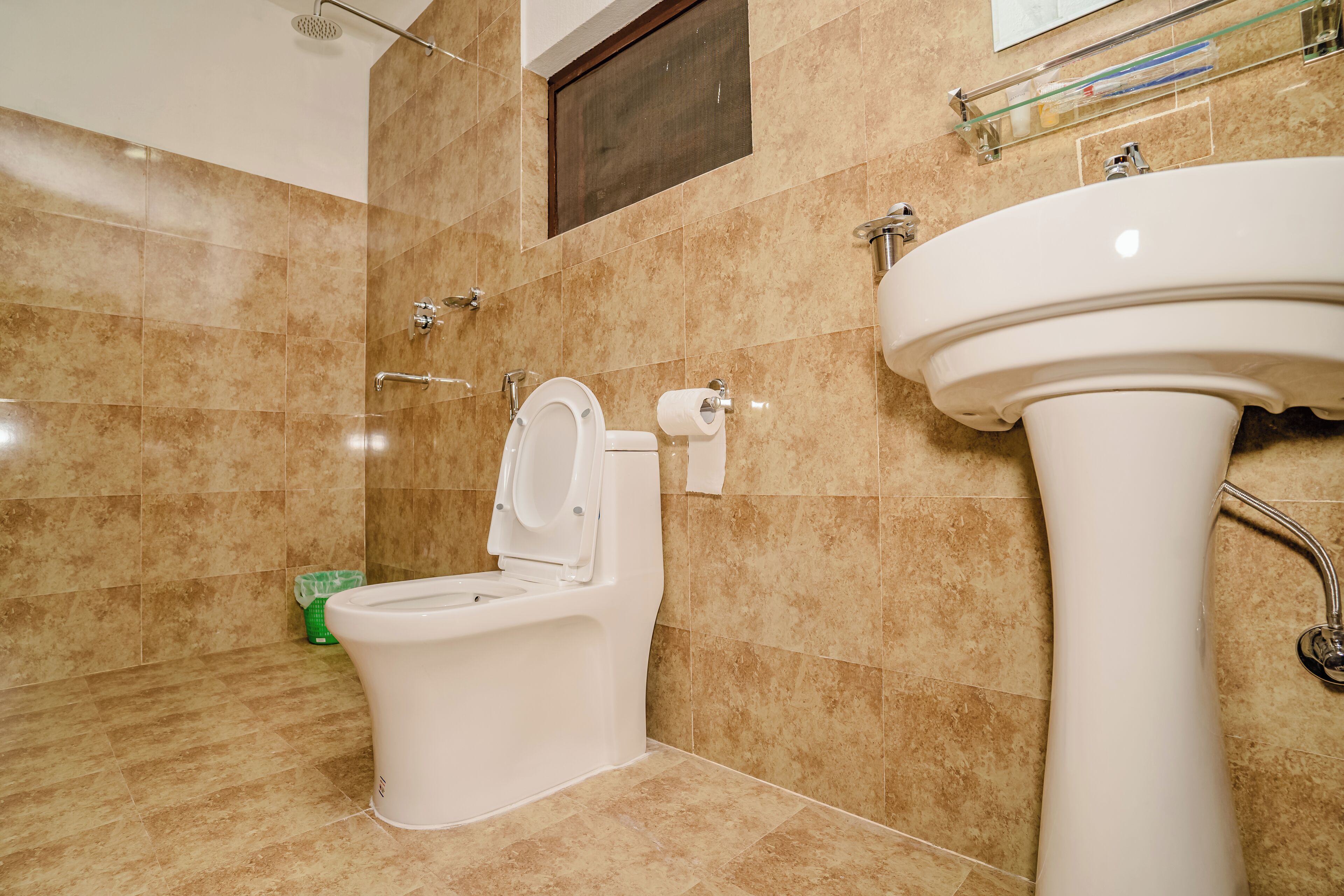 A bathroom with a toilet, sink, and shower.