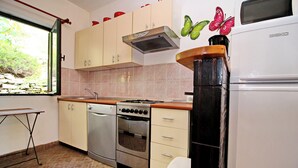 Una cucina con forno, piano cottura, microonde e pensili.
