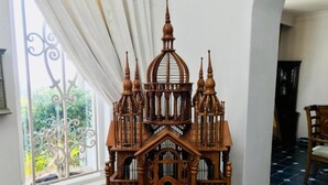 A wooden birdhouse model with intricate details and a balcony view.