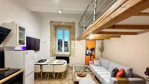 Un espacio habitable compacto con cocina, comedor y sofá.