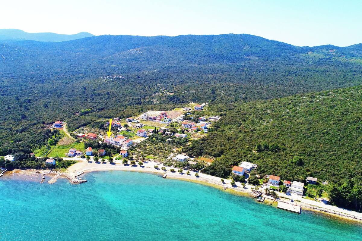 An aerial view of a coastal town with houses and a beach.