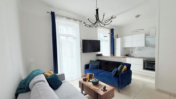Una sala de estar moderna con un sofá, una mesa de centro y un televisor.