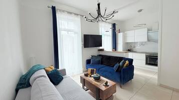 Un salon moderne avec un canapé, une table basse et un téléviseur.