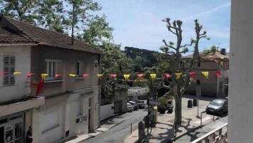 Una veduta di strada con edifici, un attraversamento pedonale e bandiere decorative.