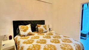 Un dormitorio con cama, mesita de noche, lámpara y candelabro.