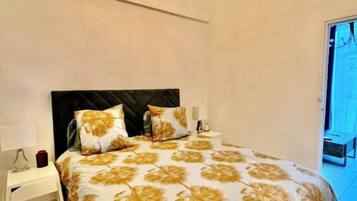 Une chambre à coucher avec un lit, une table de chevet, une lampe et un lustre.