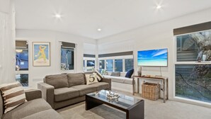 A modern living room with a sofa, coffee table, and a large window with a view of the outdoors.
