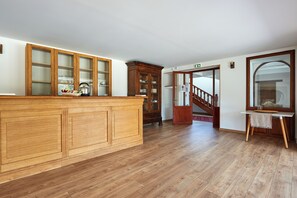 A spacious kitchen with wooden cabinets and a central island. A staircase leads to an upper level, and a large mirror is mounted on the wall. - DOMAINE DE BADINE (Saint-Sulpice-et-Cameyrac)