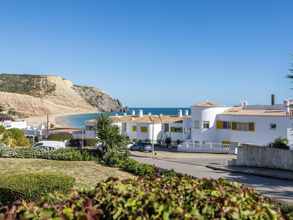 A coastal residential area with white buildings, a beach, and a cliff. - Oceanview Dream - Praia da Luz (Luz)