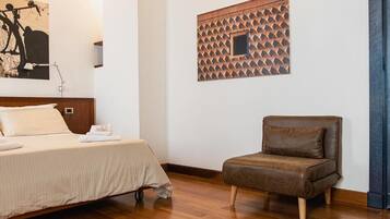 Une chambre à coucher avec un lit, un fauteuil marron, une œuvre d’art accrochée au mur et un panneau mural à motifs.