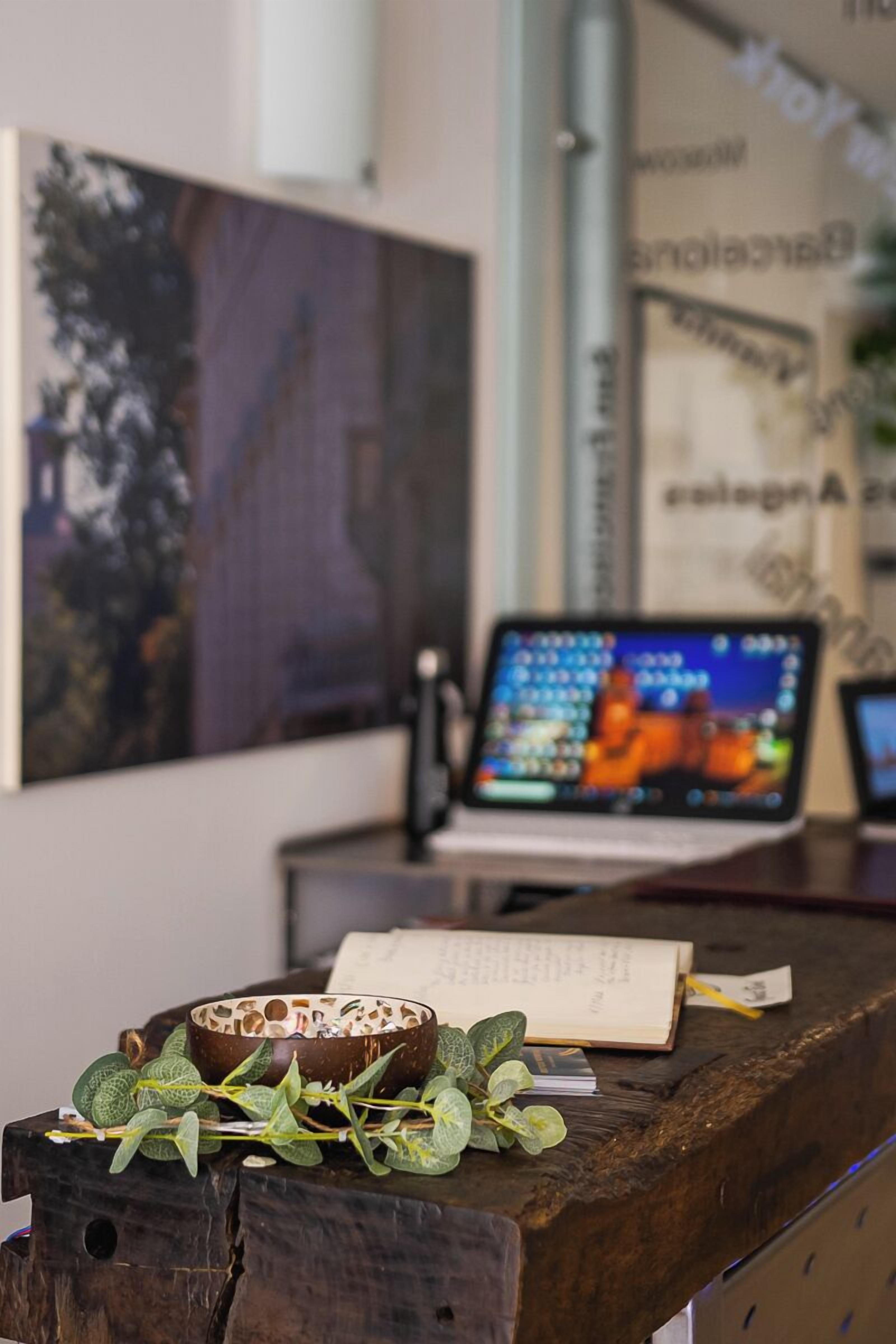 Ein Holztisch mit einem Laptop, einer Schale und einem Buch.
