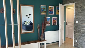 Un salon moderne avec des murs de couleur turquoise, un banc blanc et un fauteuil jaune.