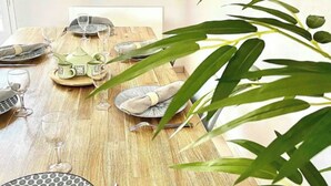 Une table à manger dressée avec des assiettes, des verres et des couverts.