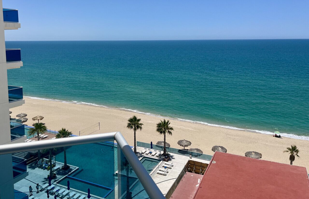 Un resort con piscina, spiaggia e vista sull'oceano.