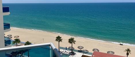A resort with a pool, beach, and ocean view.