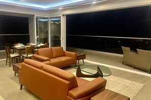 A modern living room with a sofa, coffee table, and dining area.