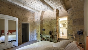 A bedroom with a large bed, a wardrobe, a desk, and a mirror. - Le Prieuré la Madelène (Malaucene)