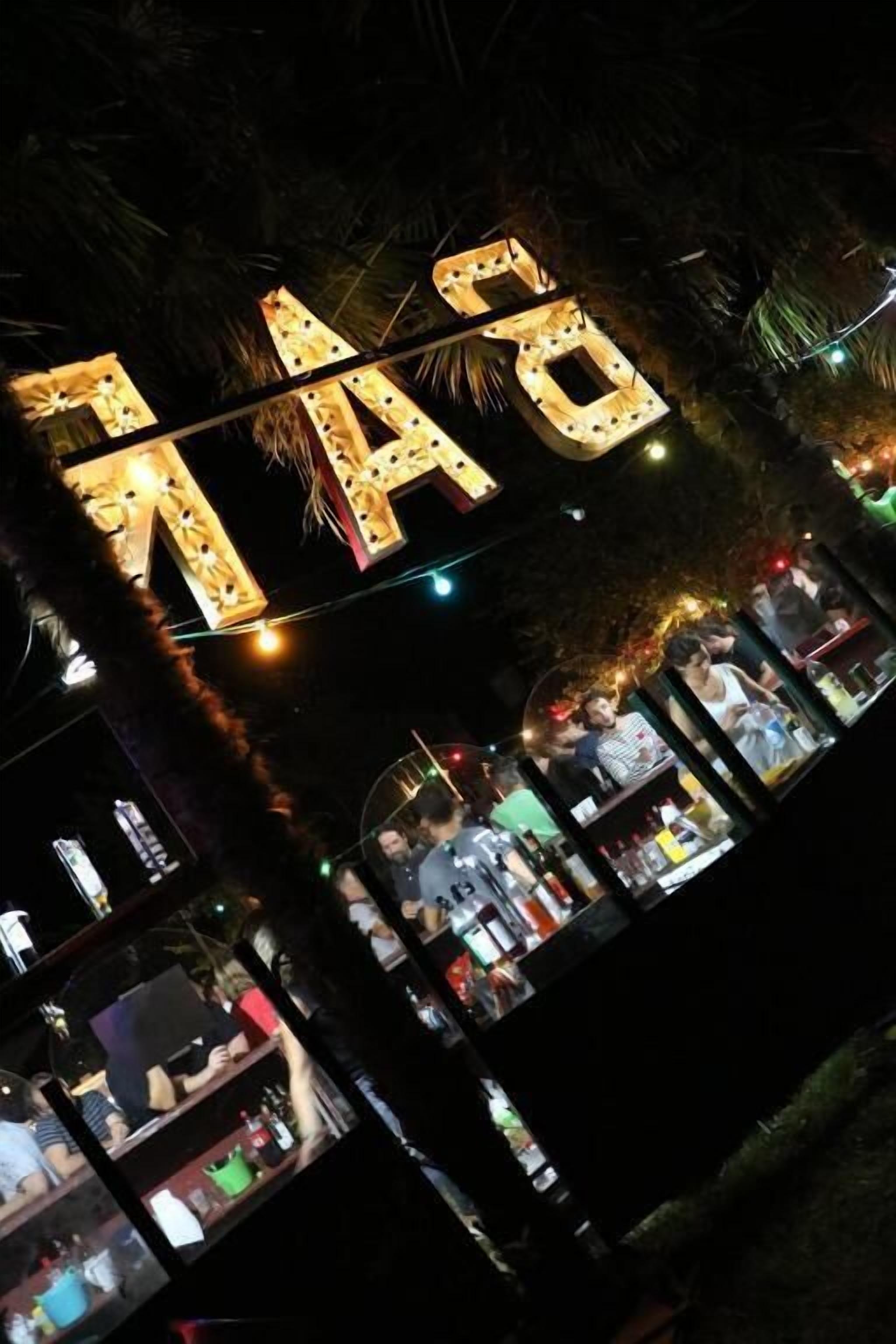 A brightly lit sign with illuminated letters spelling "NAO" against a dark background.