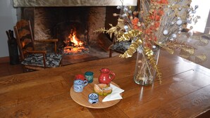 A wooden table with a vase of dried flowers, a pitcher, and a plate with bread and a cup. - Maison de Campagne au Coeur de la Double Avec Piscine (Échourgnac)