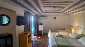 Habitación de hotel con dos camas, televisor, aire acondicionado y un pequeño armario.