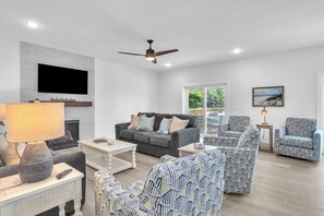 TV, fireplace, books - Trottin’ To Paradise: Charming, Spacious Rental with Private Pool (Oak Island)