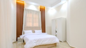 Un dormitorio moderno con una cama grande, paneles de madera y un armario.