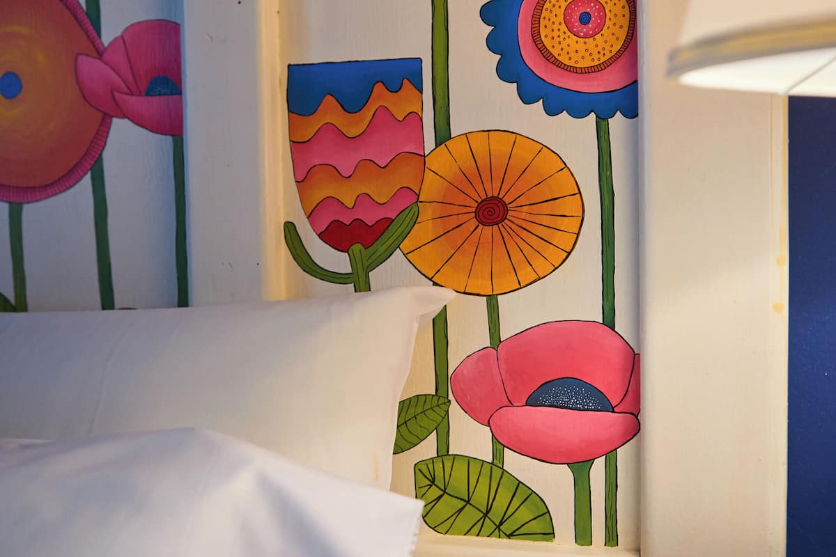 A framed artwork of colorful flowers on a wall.
