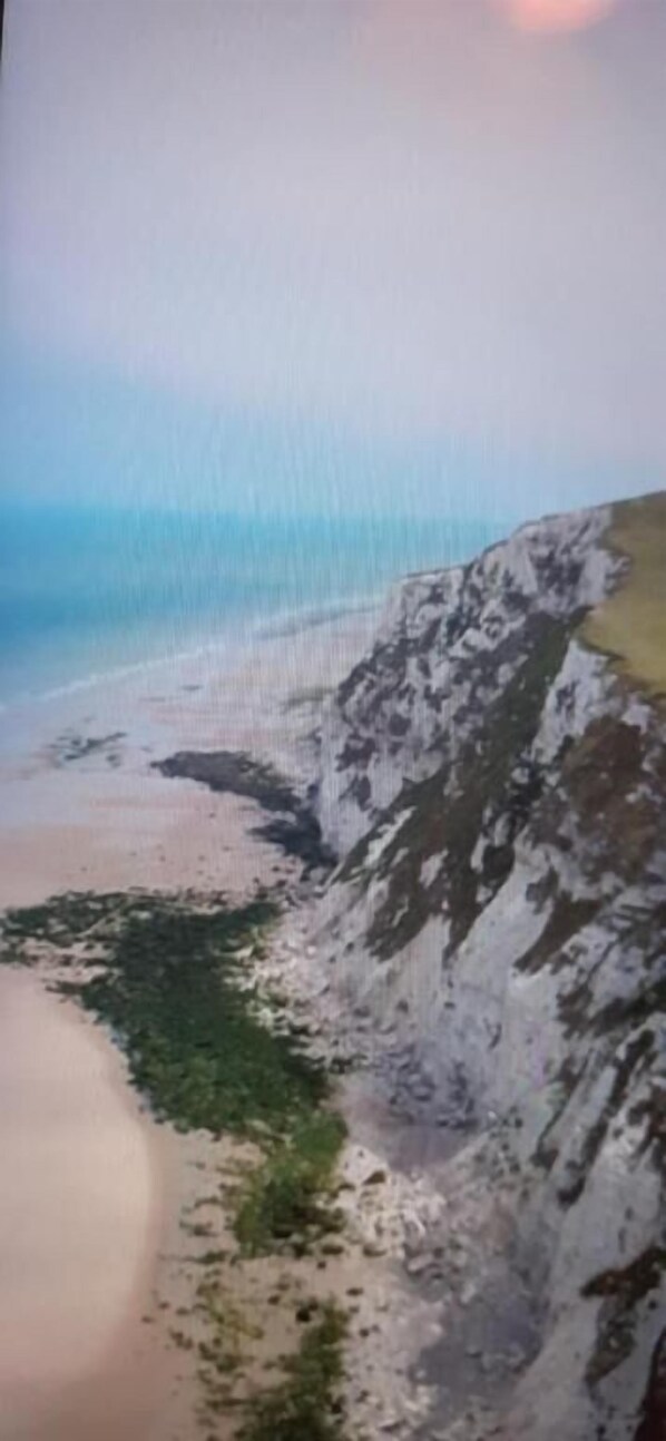 A coastal landscape with a sandy beach and rocky cliffs. - A la bonne franquette  (Marquise)