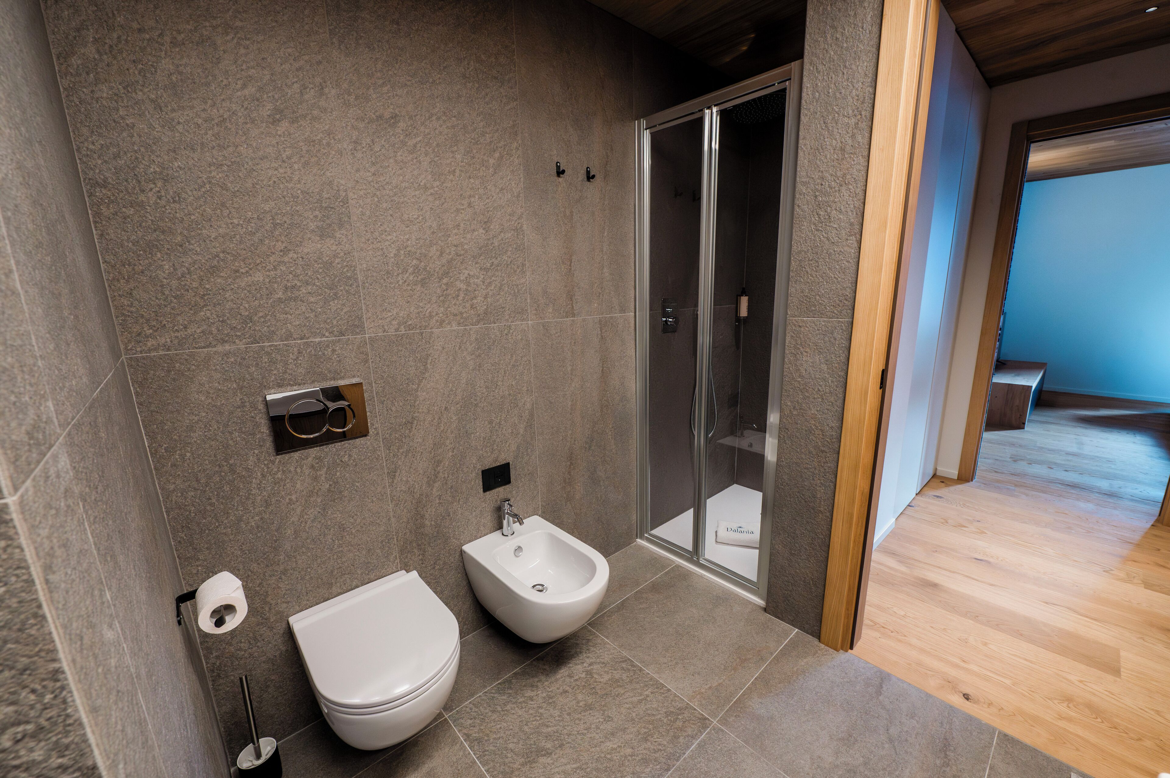Un baño moderno con bidé, inodoro y zona de ducha.