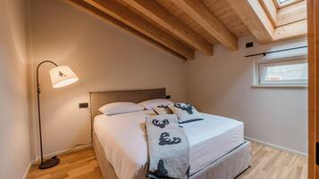 A bedroom with a bed, a floor lamp, and a skylight.