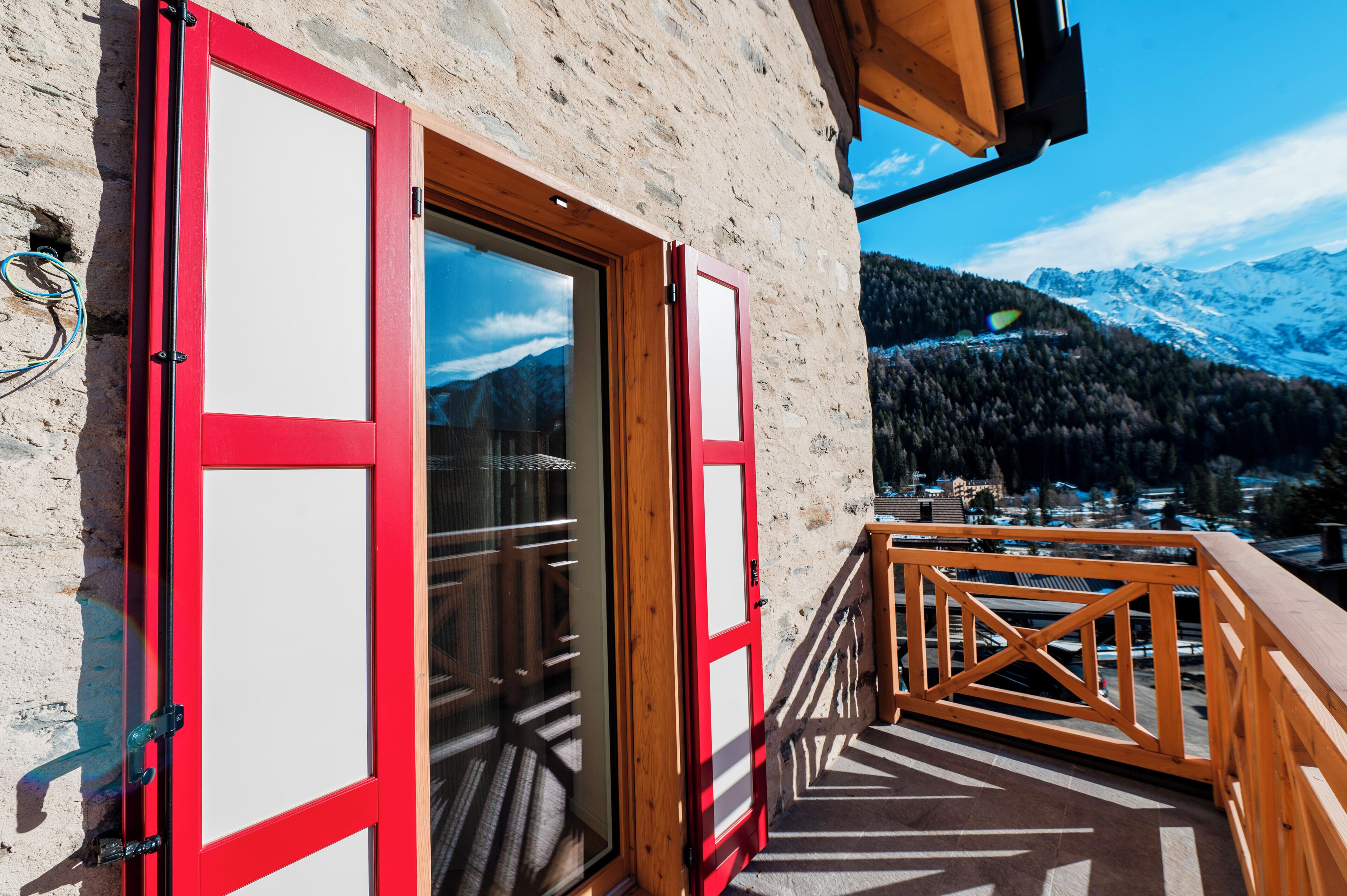A wooden balcony with a view of snow-capped mountains.