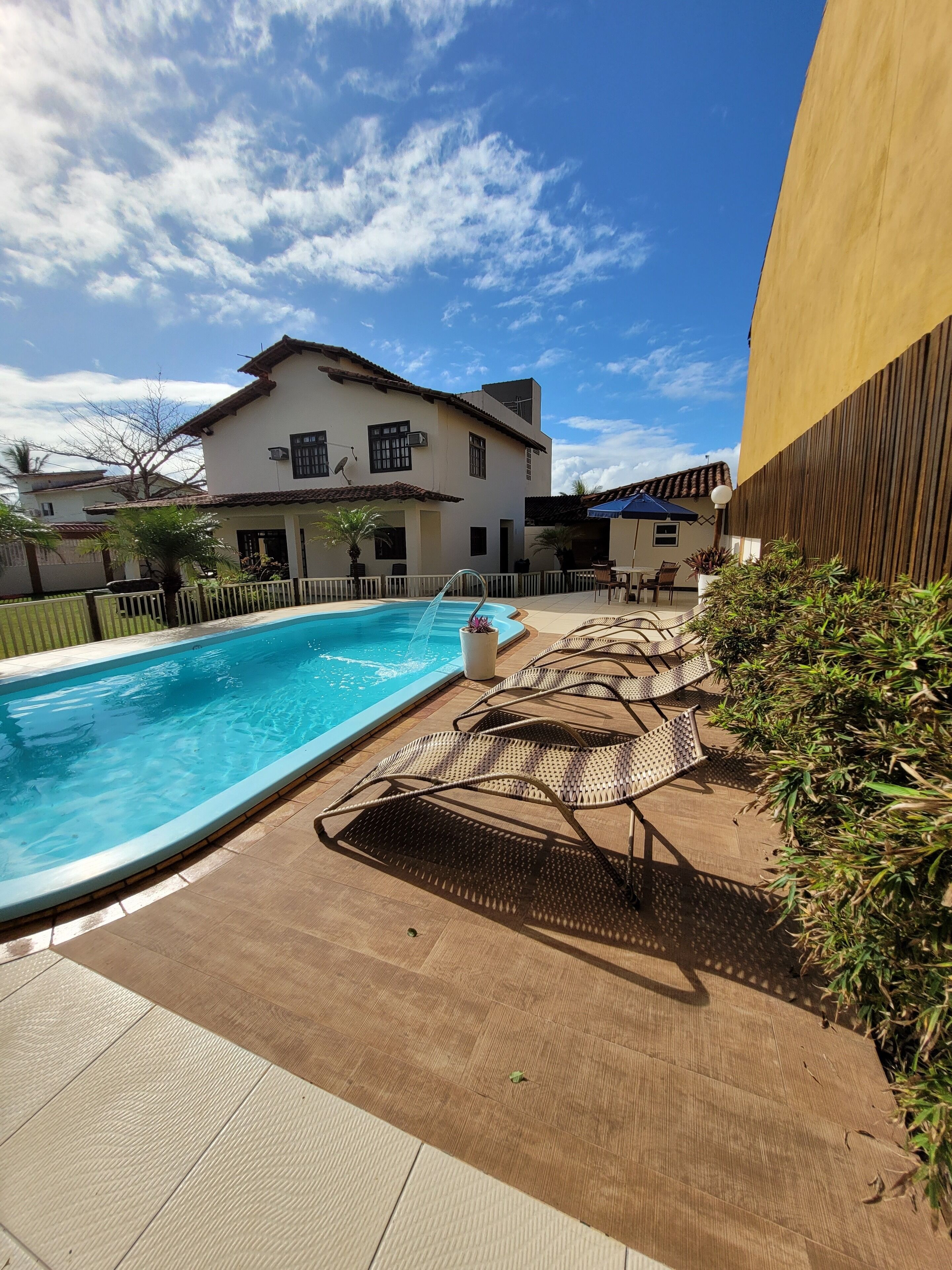 Una piscina amb gandules i un edifici al fons.
