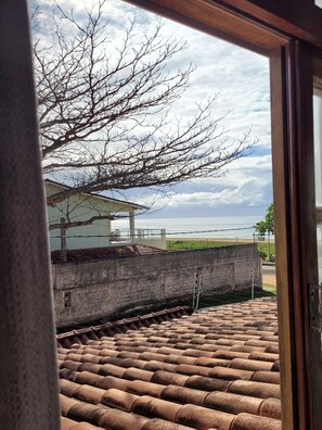 Enjoy a serene coastal view from this room's window, overlooking a tranquil body of water and distant landscape.