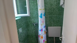 A bathroom with a shower curtain, a toilet, and a sink.