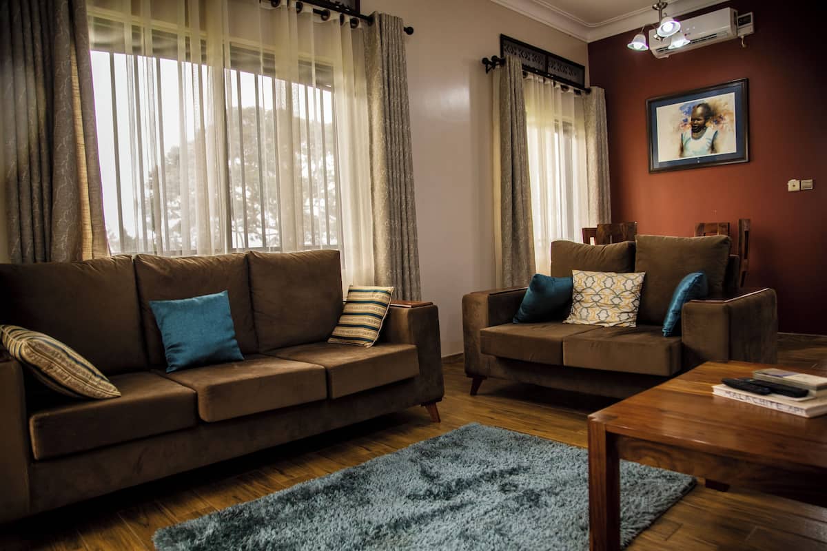 A living room with two brown sofas, a blue rug, and a wooden coffee table.