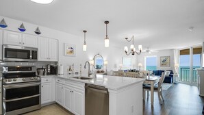 A modern kitchen with white cabinetry, stainless steel appliances, and a central island. - Upgraded 3 bedroom condo with Ocean Views (North Myrtle Beach)