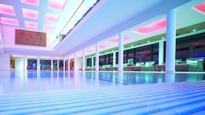 Een ruime binnenruimte met een hoge plafond, grote ramen en moderne verlichting.
