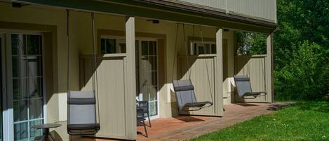 A covered patio with outdoor seating and a glass door entrance.