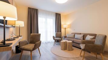 Una sala de estar moderna con un sofá, dos sillones, una mesita de centro y lámparas.