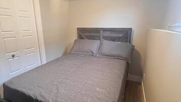 A bedroom with a bed, a wardrobe, and a door.
