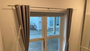 A room with a sliding glass door leading to an outdoor area with bicycles. - Design-ferienwohnung Altstadtperle Mitten im Zentrum von Hildburghausen (Hildburghausen)