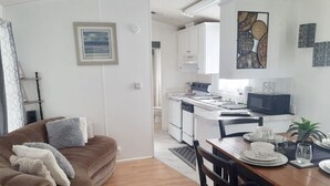 Moderni huoneisto, jossa on olohuone, ruokailutila ja keittiö.