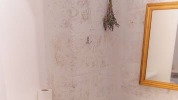 Une salle de bain avec un lavabo blanc, un miroir, un porte-serviettes et un petit panier.